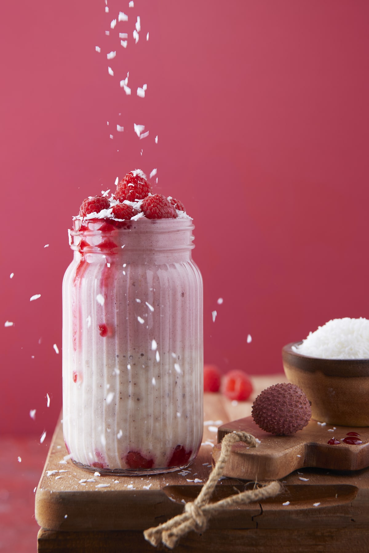 Smoothie aux framboises et au litchis, saupoudré de noix de coco râpée
