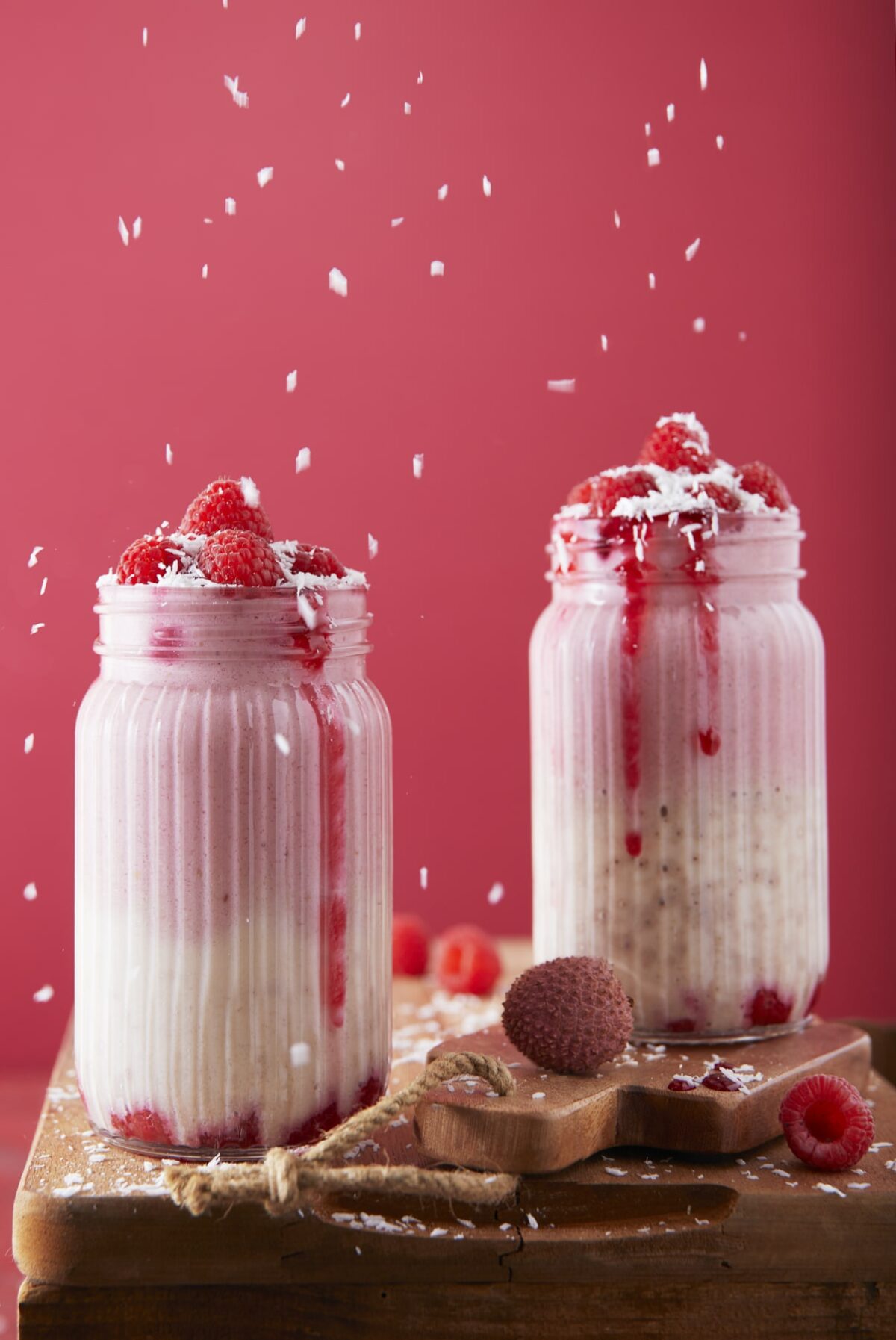 Deux smoothies framboises litchis saupoudrés de noix de coco râpée