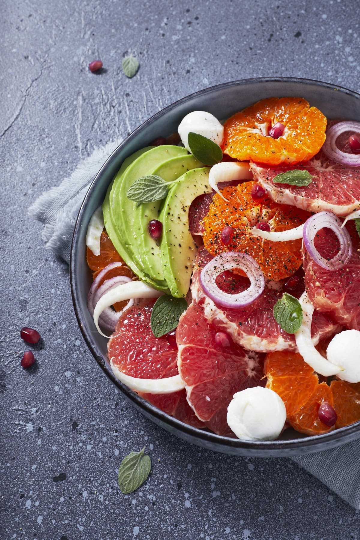 Gros plan sur une salade aux agrumes, avocat et mozzarella.