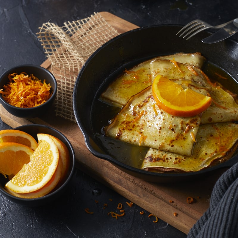 Gros plan sur des crêpes Suzette au beurre d'orange.
