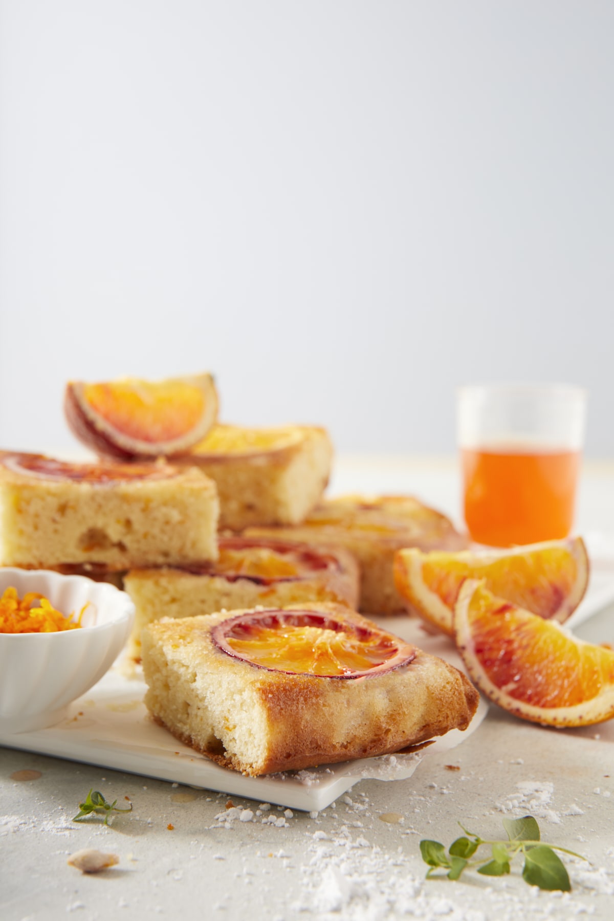 Gâteau renversé aux oranges sanguines, coupé en parts individuelles, accompagné de son sirop d'imbibage et d'une coupelle de zestes.
