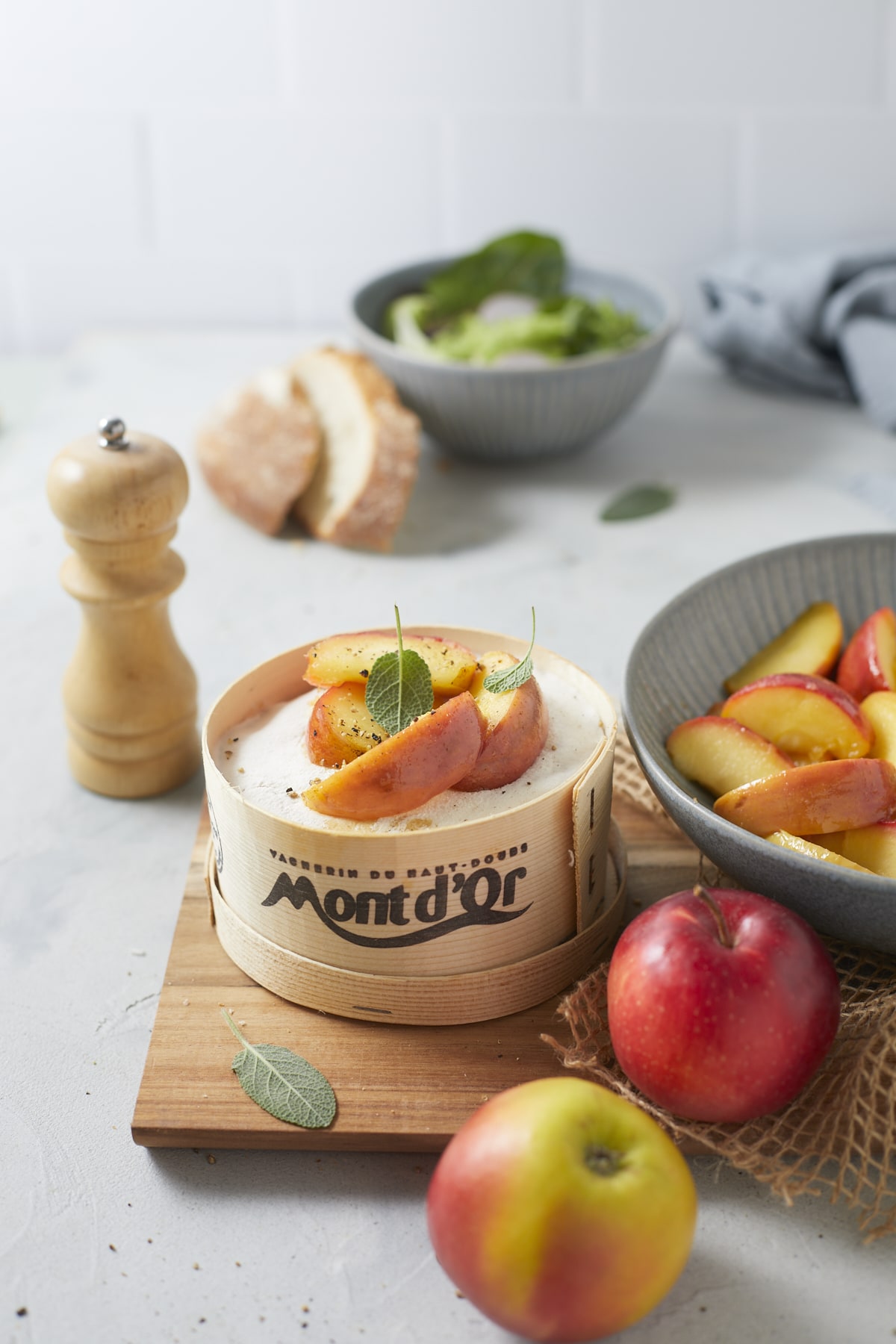 Un mont d'Or au pommes et à la sauge accompagné de pain de campagne et de salade verte.