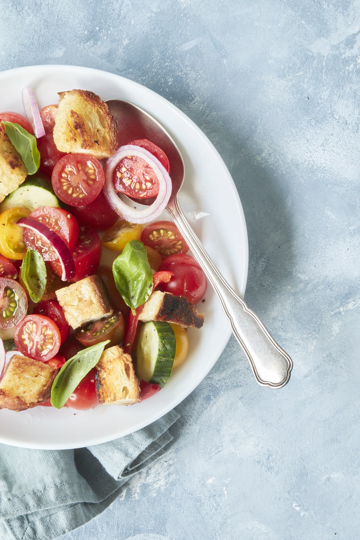 Flatlay d'une Panzanella dans une assiette blanche.