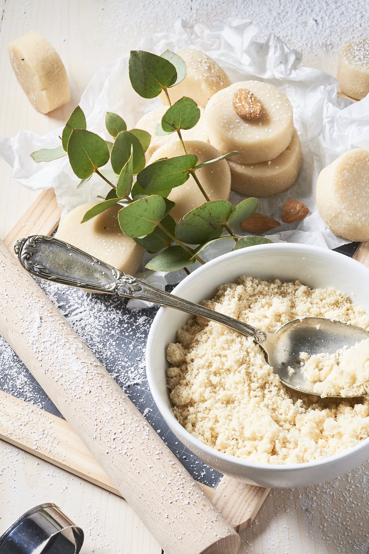 Des palets de pâte d'amande et un bol de poudre d'amandes.