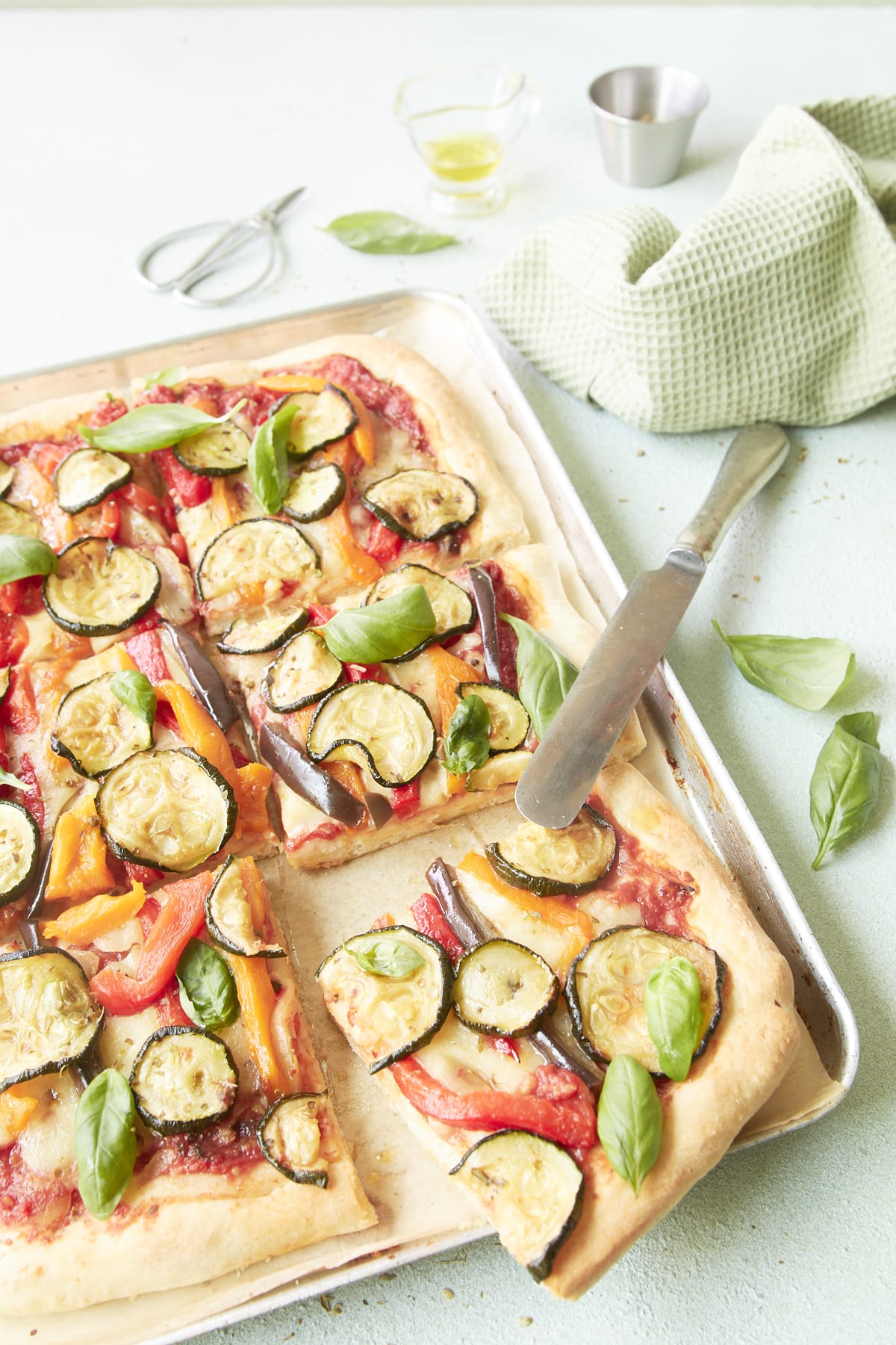 Pizza aux légumes grillés, découpée en parts.