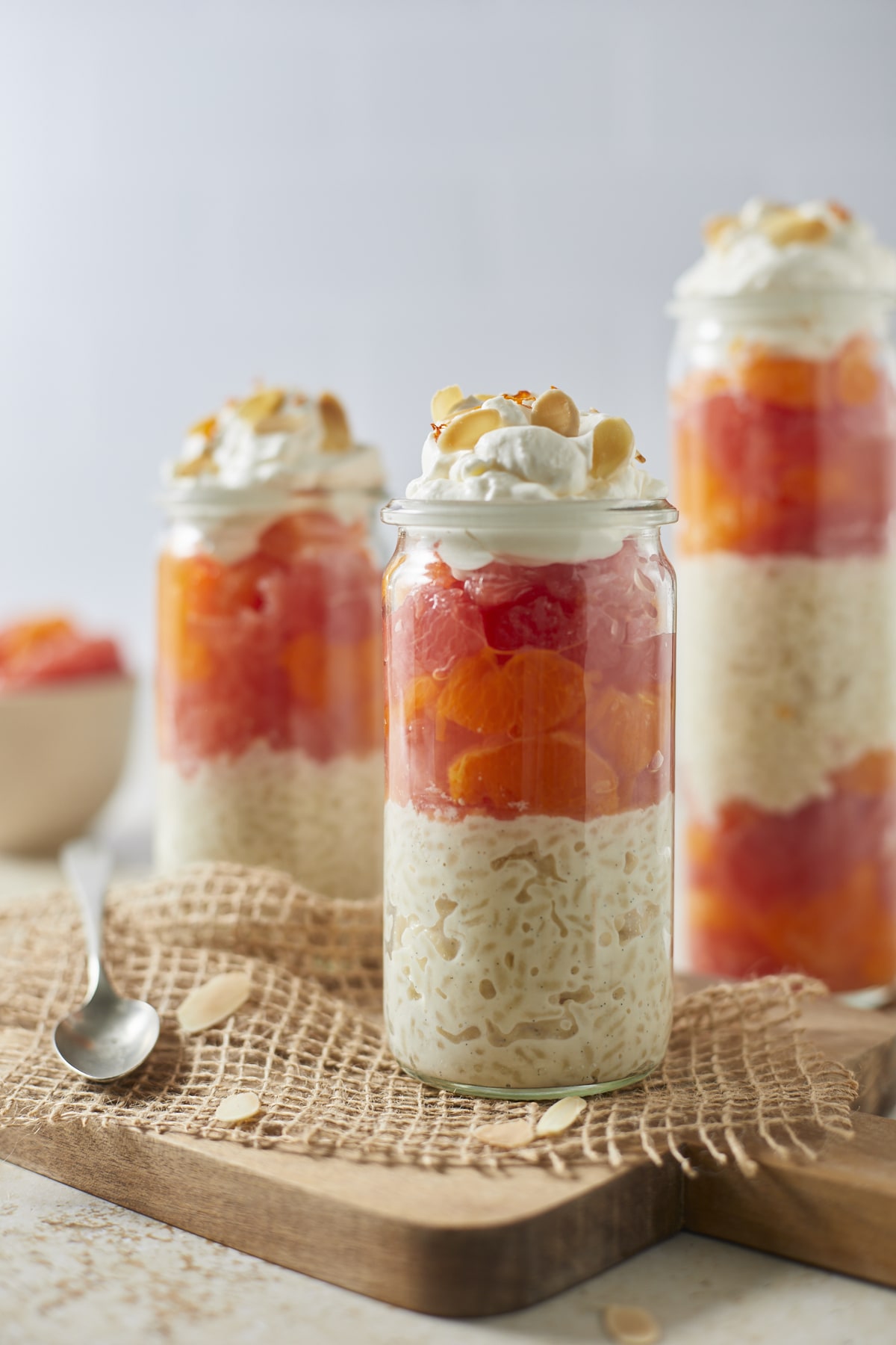 Riz au lait d'amande aux agrumes en bocaux décorés de chantilly et d'amandes grillées