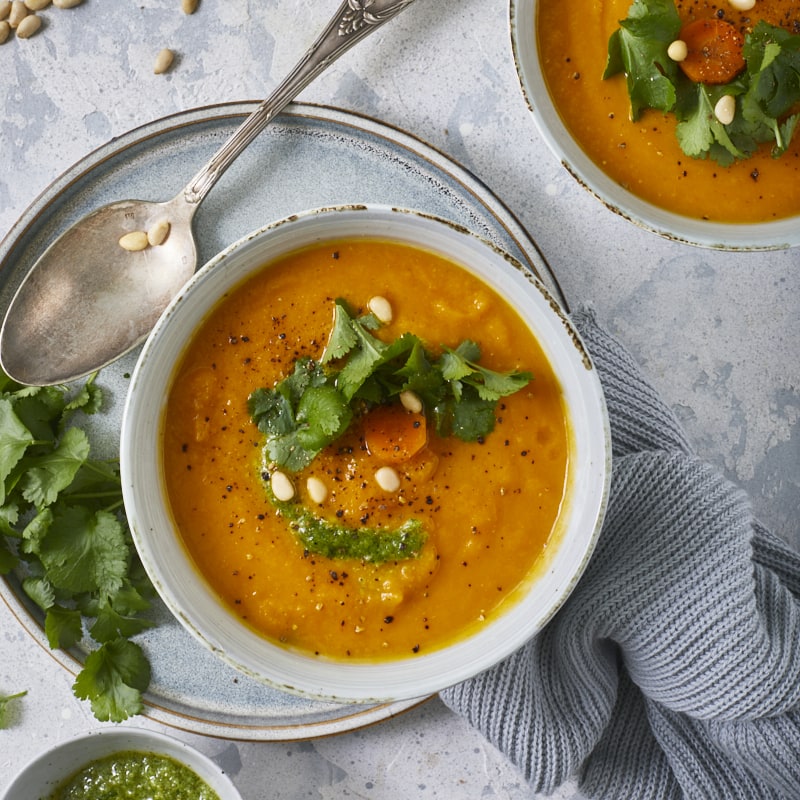 Soupe de carottes aux lentilles corail servie avec un pesto de coriandre.