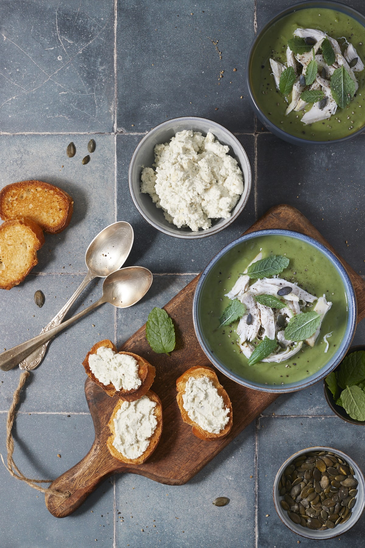 Soupe verte de brocolis et de poulet servie dans des bols et accompagnée de toasts au fromage.