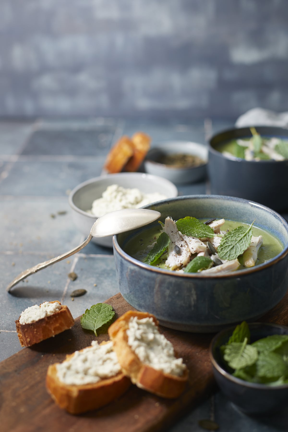 Soupe verte de brocolis au poulet servie dans des bols et accompagnée de tartines grillées.