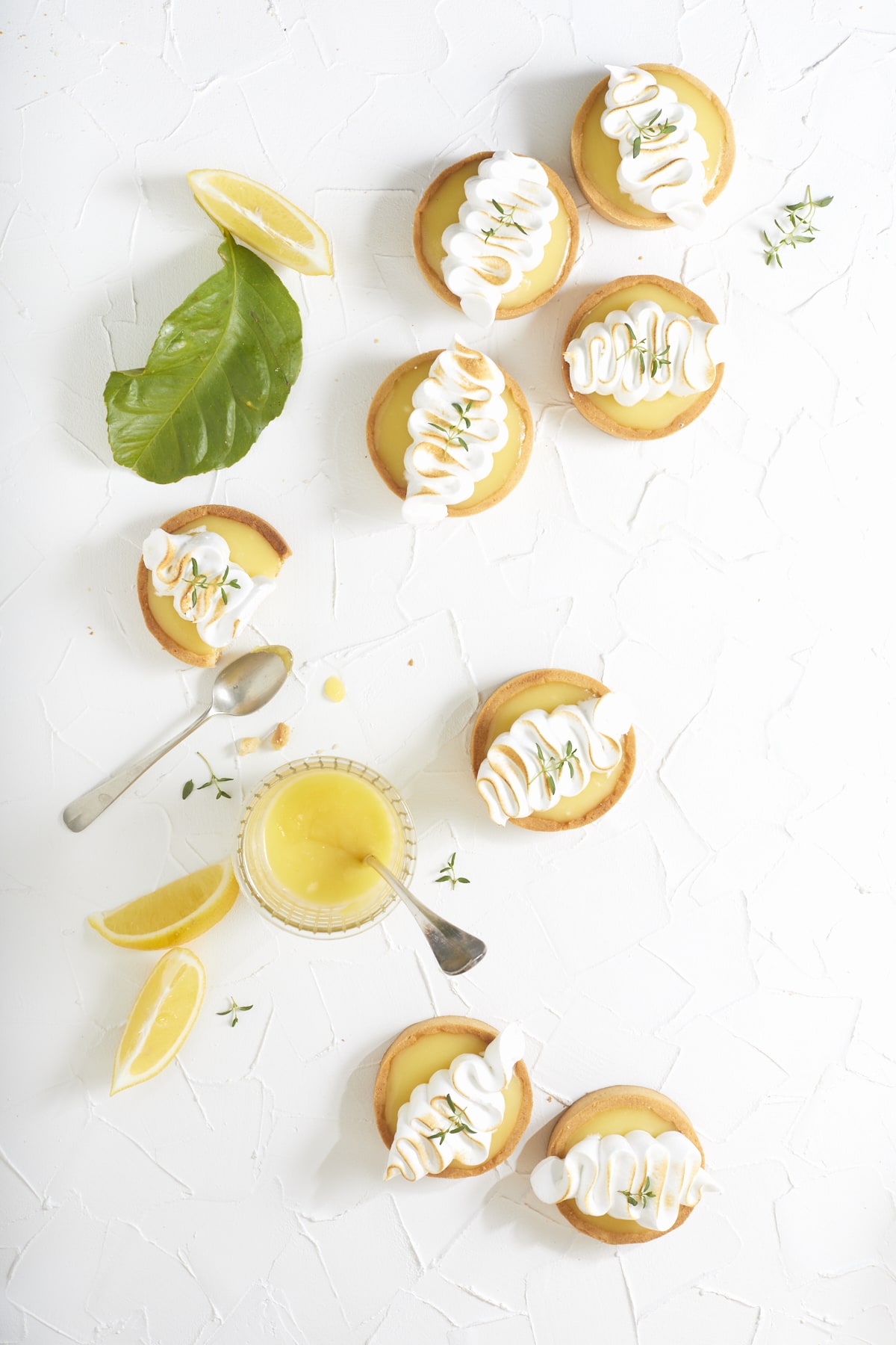 Tartelettes citron meringuées photographiées en flat lay sur fond blanc