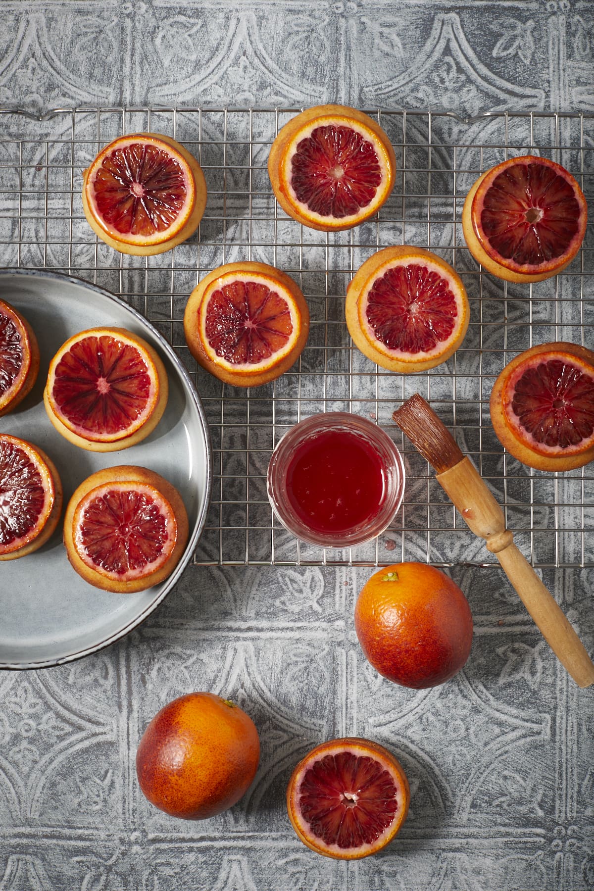 Dix mini cakes aux oranges sanguines présentés sur une grille.