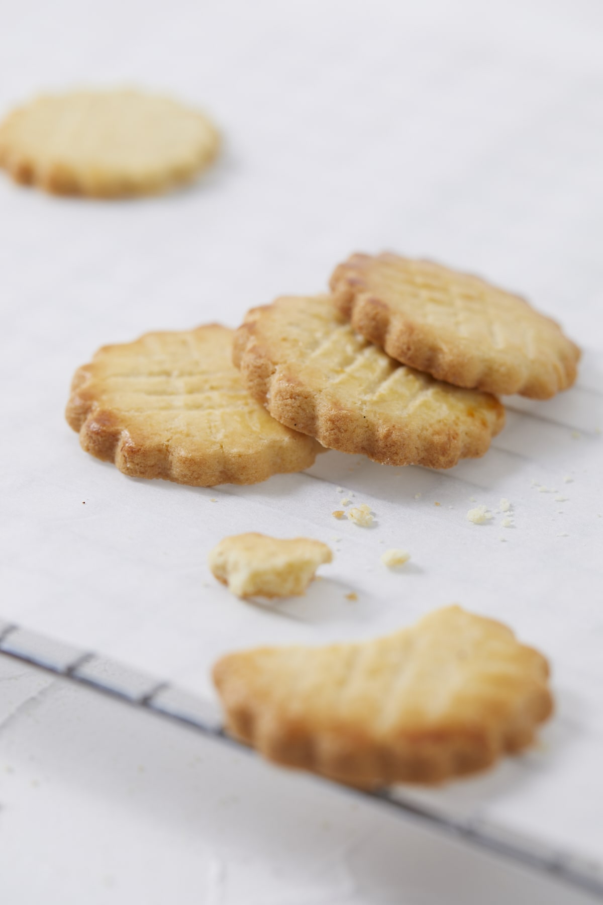 Des galettes bretonnes pur beurre posées sur une grille, l'une d'elle est déjà croquée.