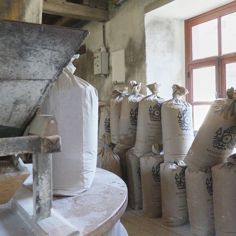 Fin de journée au Moulin de Hollange, les meules sont à l'arrêt et des sacs de farine adossés au mur attendent d'être livrés.