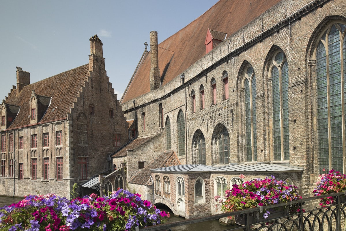 Des bacs de fleurs surplombent un canal, le long de l'hôpital Saint-Jean.