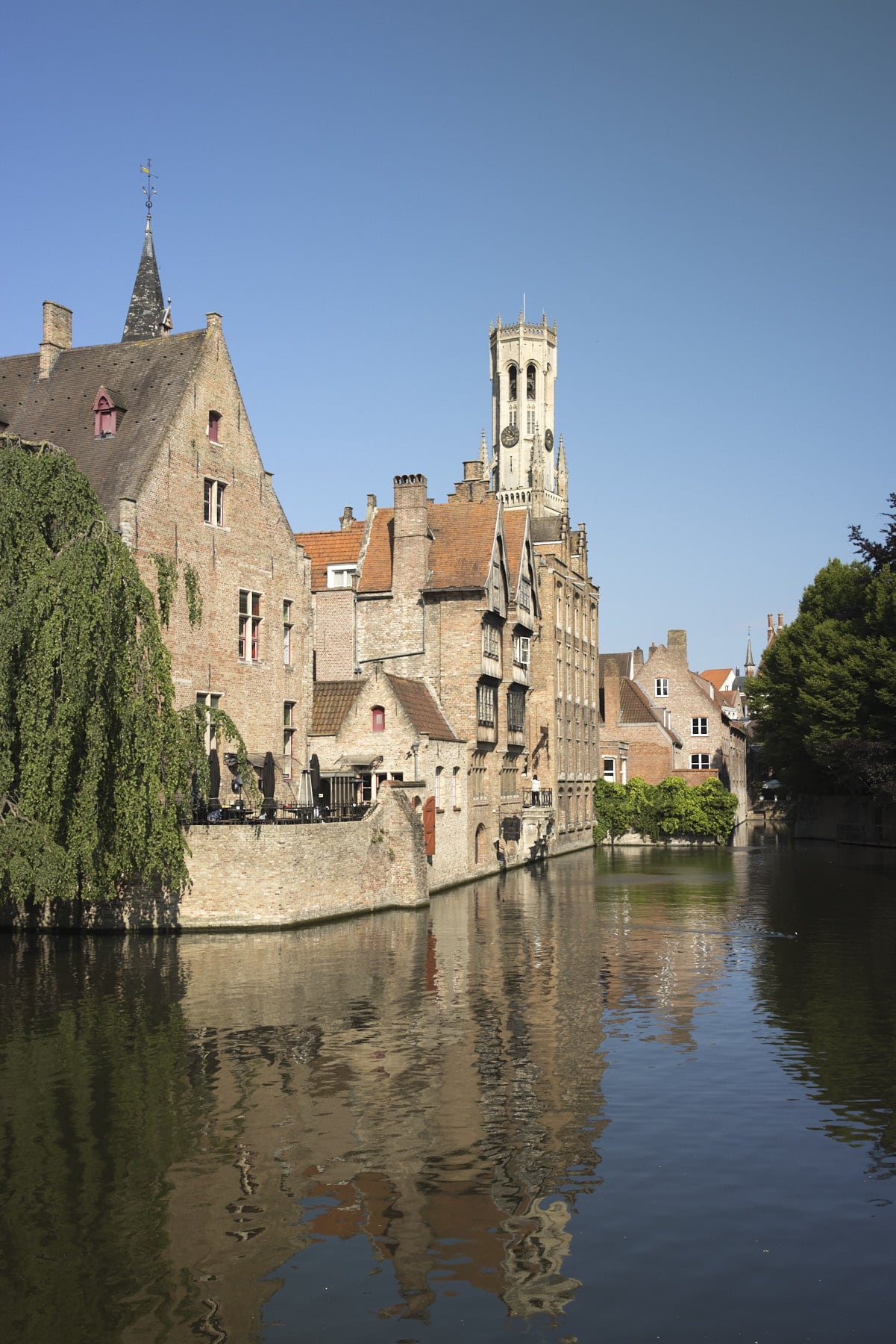 Maisons historiques et beffroi de Bruges se reflétant dans un canal