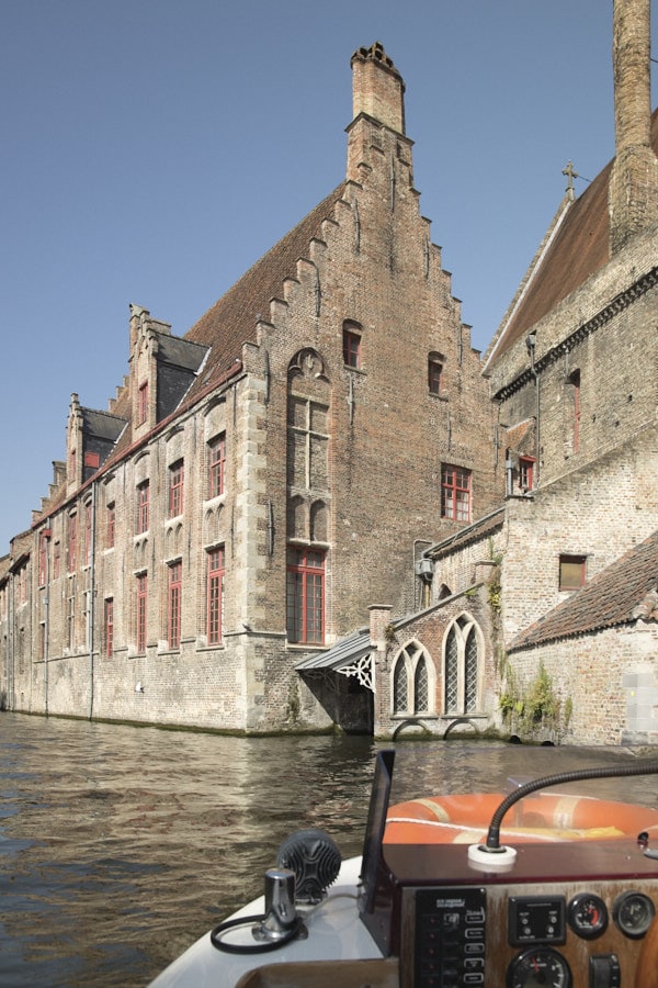 Promenade en bateau sur un canal bordé de maisons historiques à Bruges