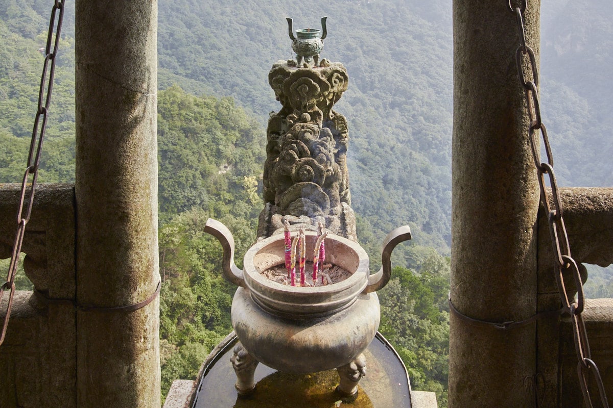Encensoir sculpté en forme de tête de dragon au-dessus du précipice.