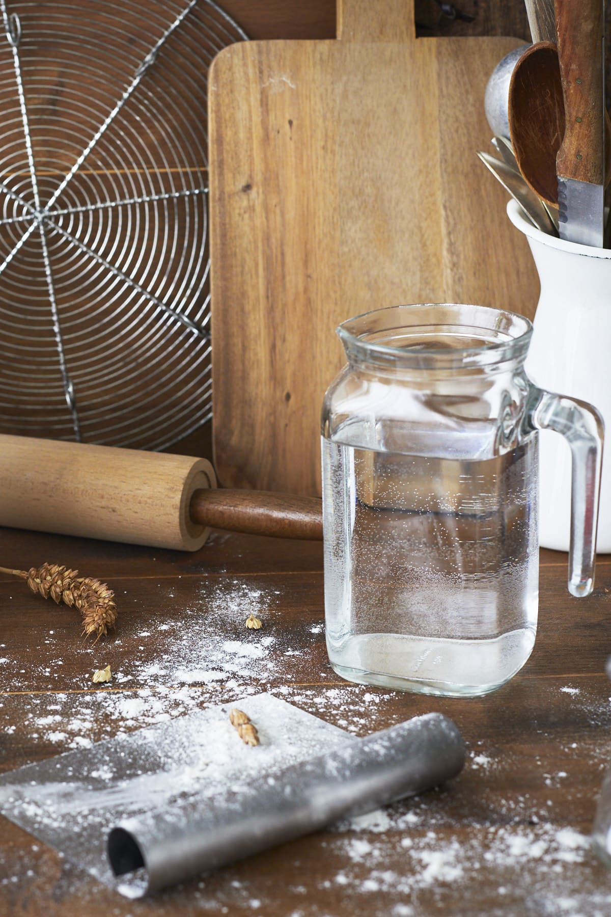 De la farine résiduelle traîne sur le coupe pâte, à côté de la carafe d'eau.
