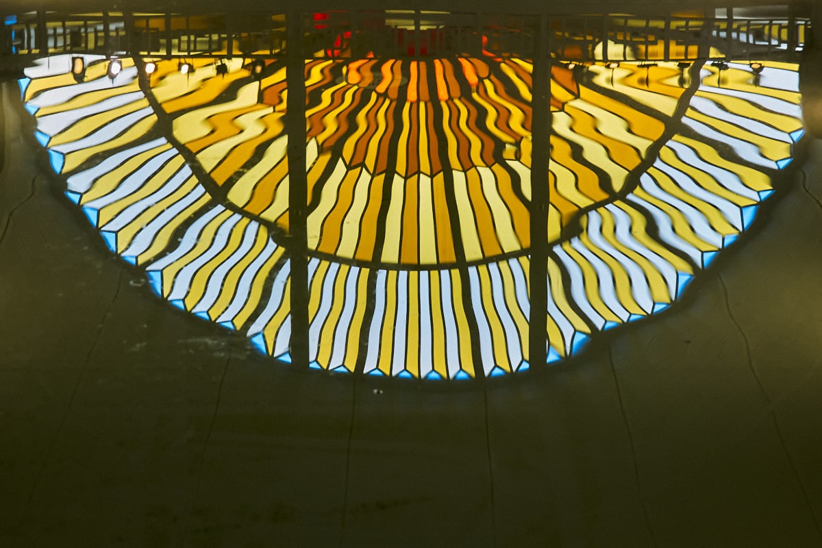 L'un des deux vitraux en forme de soleil qui se reflète dans la piscine.