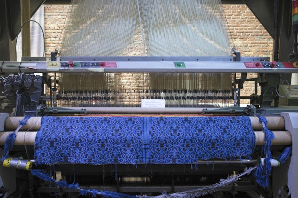Métier à tisser avec un tissu bleu électrique en fabrication