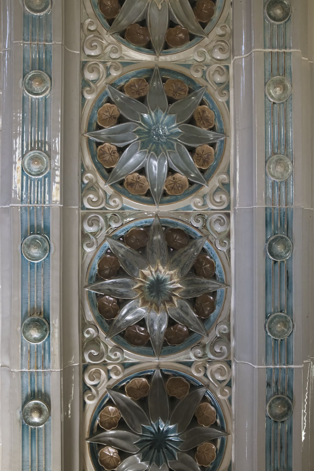 Gros plan sur les céramiques de l'arche art déco de la piscine.