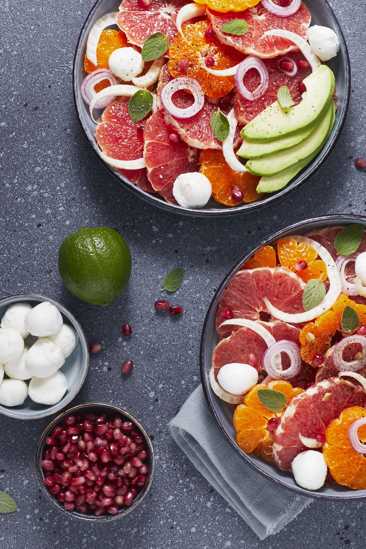 Deux assiettes de salade aux agrumes, avocat et mozzarella.