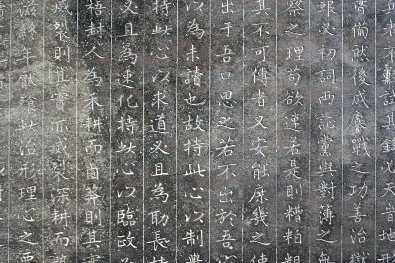 Une pierre gravée de caractères calligraphiques chinois.