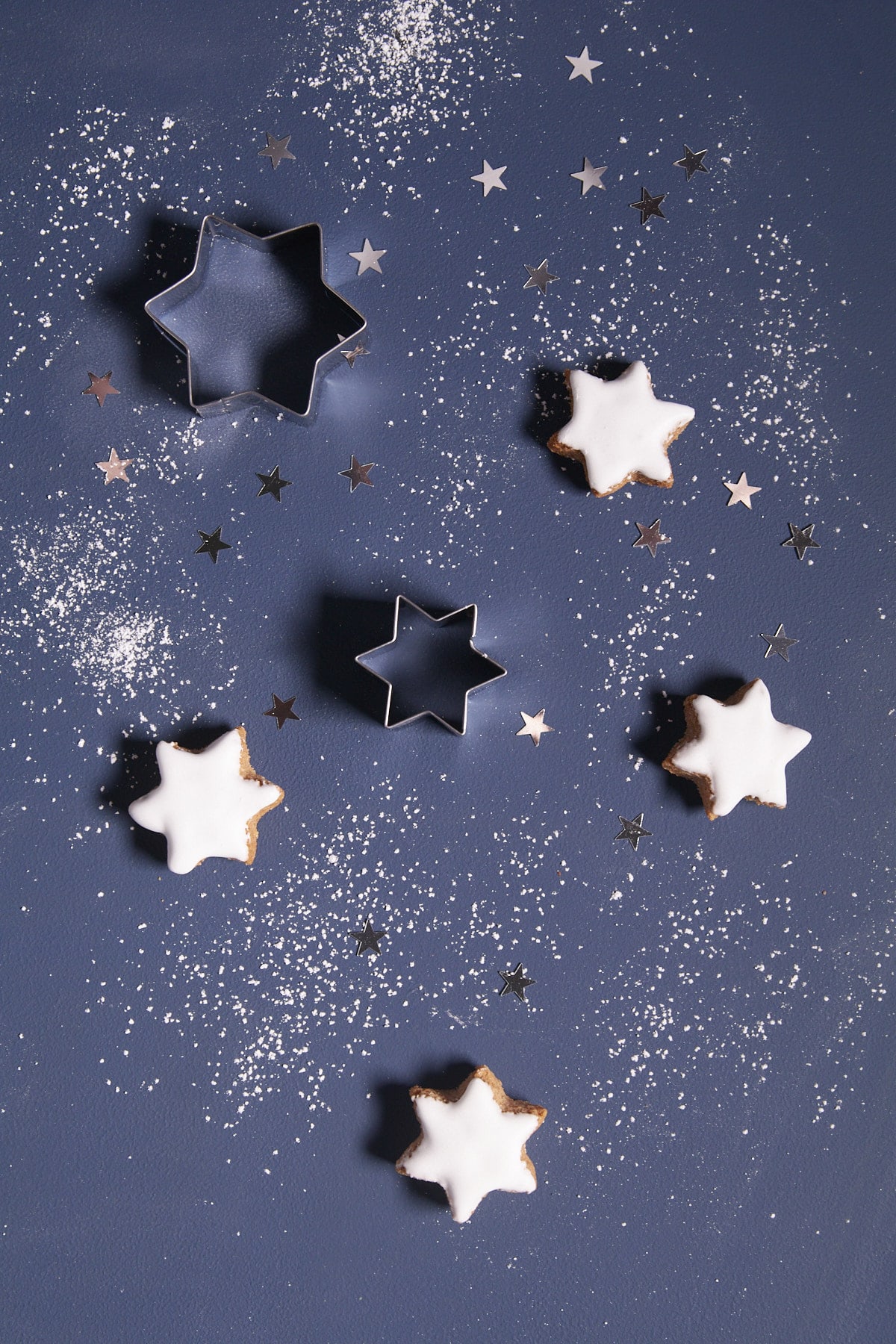 Biscuits étoiles de Noël et sucre glace sur fond bleu en composition flat lay