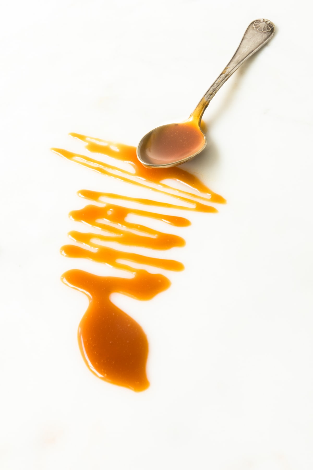 Espace négatif en photographie culinaire avec cuillère et caramel sur fond blanc