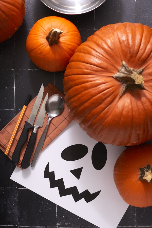 Courges, couteaux, cuillère et modèle de visage pour fabriquer une lanterne d’Halloween